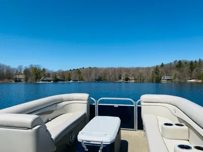 A pontoon boat on the calm, open water of Pearl Lake on a clear summer day
